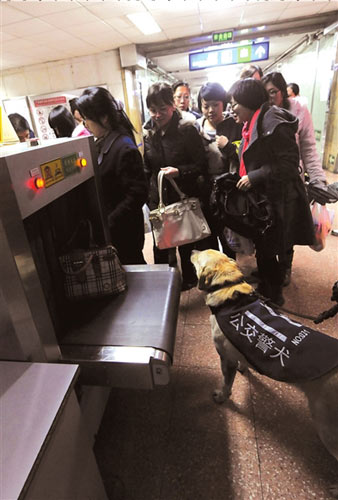  Police patrols aided with sniffer dogs are seen at Beijing&apos;s metro stations on March 30, 2010. [Xinhua]