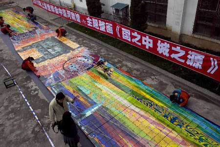 Workers clean a huge mural for the 2010 World Expo in Luoyang, central China's Henan Province, March 30, 2010. The 26-meter-long and 3.2-meter-high mural of Tang Tri-colored pottery for the Henan Pavilion in Expo Park is packed and transported to Shanghai on Monday. Photo: Xinhua