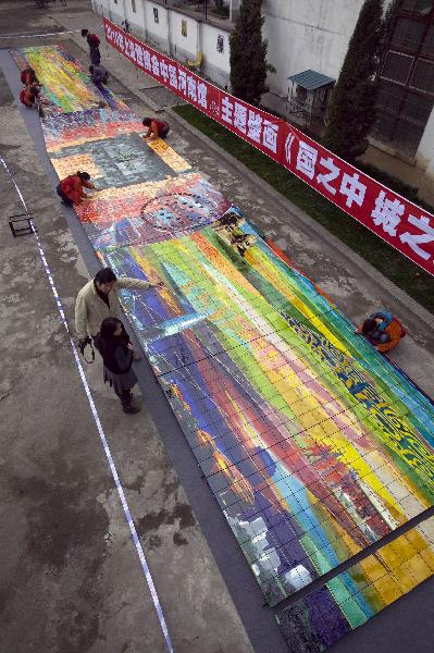 Workers clean a huge mural for the 2010 World Expo in Luoyang, central China's Henan Province, March 30, 2010. The 26-meter-long and 3.2-meter-high mural of Tang Tri-colored pottery for the Henan Pavilion in Expo Park will be packed and transported to Shanghai.