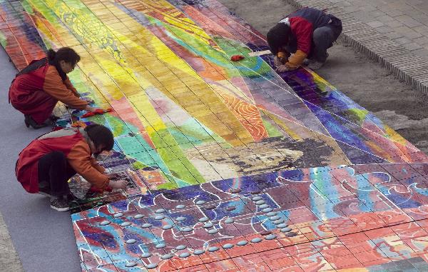 Workers clean a huge mural for the 2010 World Expo in Luoyang, central China's Henan Province, March 30, 2010. The 26-meter-long and 3.2-meter-high mural of Tang Tri-colored pottery for the Henan Pavilion in Expo Park will be packed and transported to Shanghai.