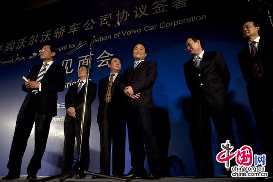 Li Shufu, 3rd from right, Chairman of Chinese Geely, smiles while standing on a stage with other Geely executives during a press conference in Beijing, March 30, 2010. [CFP]