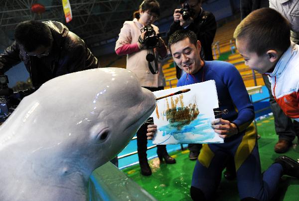 Photo taken on March 31, 2010, shows a dolphin named Xiaoqiang paint under the instructions of its tamer in an aquatic park in Qingdao, east China&apos;s Shandong Province. [Xinhua/Reuters]