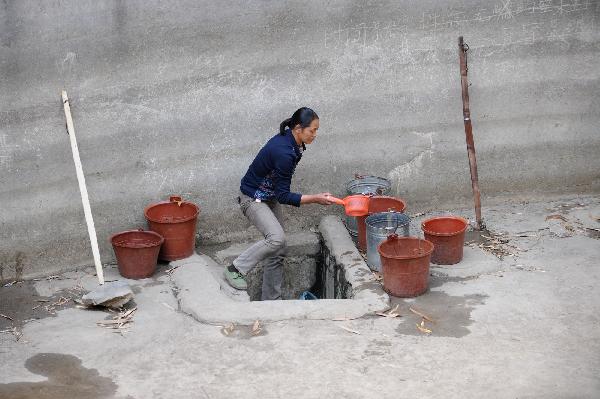  A villager fetch water from the bottom of a pool in Tian'e county of south China's Guangxi Zhuang Autonomous Region, on March 27, 2010. More than three million residents are suffering from water shortage in Guangxi which was hit by the worst drought in a century.[Xinhua]