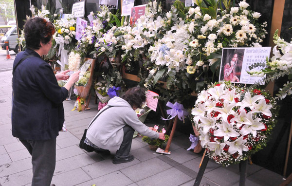 Bouquets and photographs of the late Hong Kong singer-actor Leslie Cheung are seen in front of the Mandarin Oriental Hotel in Hong Kong in this series of photos taken on March 31, 2010. 