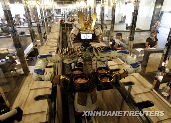 A robot waiter serves food to customers at Hajime Japanese restaurant in Bangkok April 1, 2010. Restaurant owner Lapassarad Thanaphant said she spent 30 million baht (US$927,600) on the Japanese restaurant including the purchase of four robots from Japan. [Xinhua/Reuters]