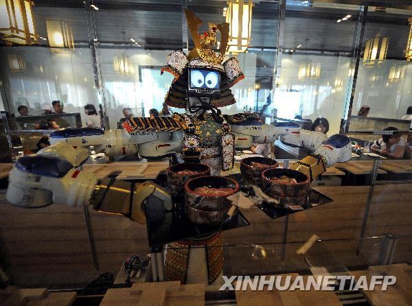 A robot waiter serves food to customers at Hajime Japanese restaurant in Bangkok April 1, 2010. Restaurant owner Lapassarad Thanaphant said she spent 30 million baht (US$927,600) on the Japanese restaurant including the purchase of four robots from Japan. [Xinhua/Reuters]