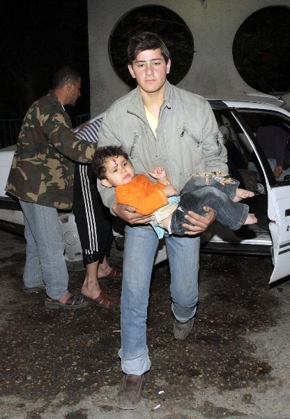 A wounded Palestinian girl is carried into Al-Shifa hospital following Israeli air strikes in Gaza April 2, 2010. [Xinhua]