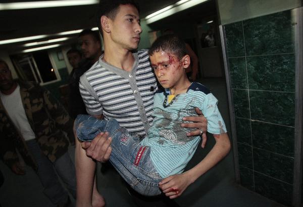 A wounded Palestinian boy is carried into Al-Shifa hospital following Israeli air strikes in Gaza April 2, 2010. [Xinhua] 