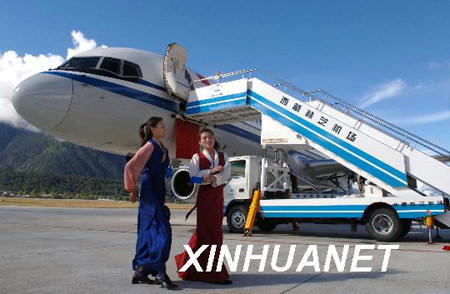 Undated file photo shows two Tibetan grils walking past a plane at the Mainling Airport in southeastern Tibet's Nyingchi Prefecture. (Xinhua Photo) 