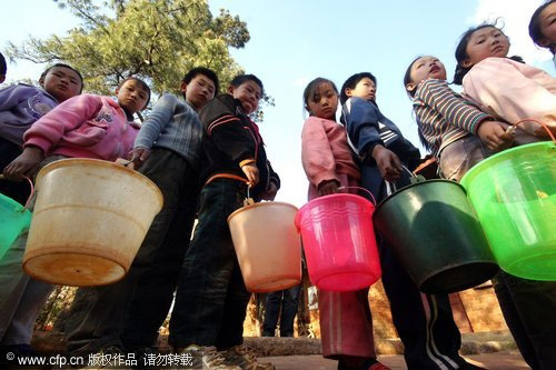 Students wait in line for water at a local school in Xundian autonomous county, in Southwest China's Yunnan province on March 31, 2010. [CFP]