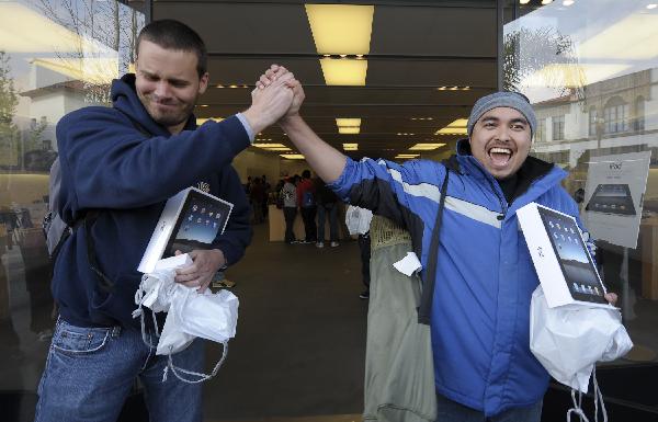 Two apple fans cheer as they bought the iPad after a whole night's waiting in an Apple distribution store in California, USA. [Xinhua]