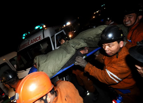 A survivor is rushed to an ambulance by rescuers after being lifted out of the shaft of the flooded Wangjialing coal mine in north China's Shanxi Province early Monday morning, April 5, 2010. [Photo/Xinhua] 