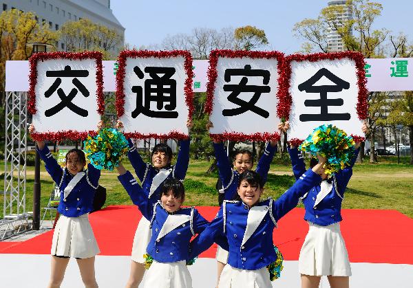 Girls perform to raise people&apos;s awareness of traffic safety during a propaganda in Osaka, Japan, April 6, 2010. [Xinhua]