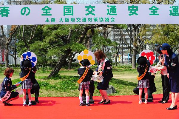 Kindergarten children play traffic games during a spring traffic safety propaganda in Osaka, Japan, April 6, 2010. [Xinhua] 