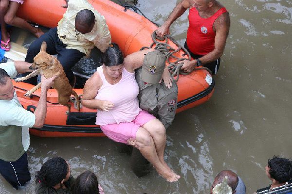 Rescue workers carry an injured woman after a landslide at Morro dos Prazeres slum in Rio de Janeiro April 7, 2010. The most intense rain in half a century triggered flooding and mudslides that killed at least 95 people in southeastern Brazil, most of them in the Rio de Janeiro area, authorities said Tuesday.[Xinhua]