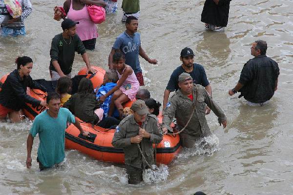 Rescue workers carry an injured man as other victims are helped after a landslide in a flooded area of Campo Grande neighborhood, Rio de Janeiro, April 7, 2010. The most intense rain in half a century triggered flooding and mudslides that killed at least 95 people in southeastern Brazil, most of them in the Rio de Janeiro area, authorities said Tuesday.[Xinhua]