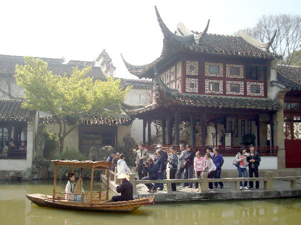 A female performer sitting inside an archaic boat entertains the excursionists with Suzhou Pingtan, a typical folklore art form of ballad-singing and story-telling, inside the Liuyuan Garden of Suzhou, east China's Jiangsu Province, April 5, 2010. The renowned Suzhou Garden put on series of tourist programme typical of local Wu Culture to lure tourists from both home and overseas during the vacationing of Qingming Festival. (Xinhua)