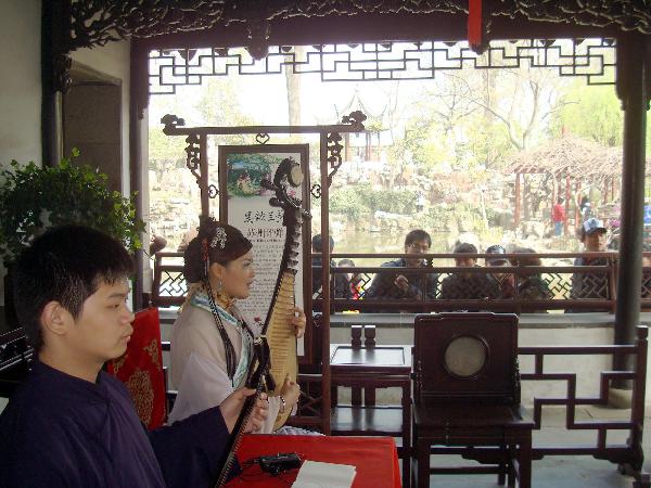 A pair of performers sitting inside an archaic style pavilion entertain the excursionists with Suzhou Pingtan, a typical folklore art form of ballad-singing and story-telling, inside the Liuyuan Garden of Suzhou, east China's Jiangsu Province, April 5, 2010. The renowned Suzhou Garden put on series of tourist programme typical of local Wu Culture to lure tourists from both home and overseas during the vacationing of Qingming Festival. [Xinhua/Wang Jiankang]