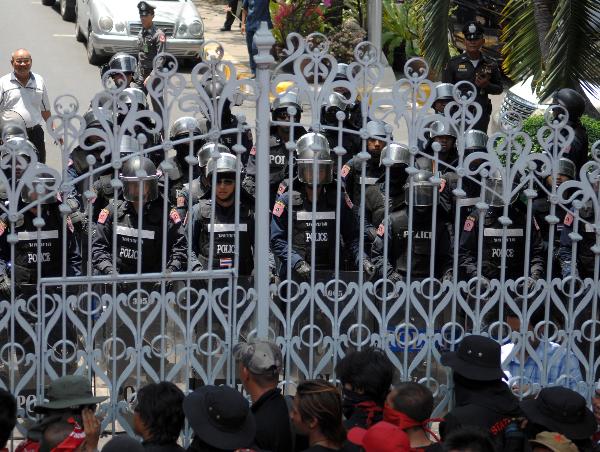 Thailand's red-shirted protesters confront with policemen and soldiers at the gate of the Parliament House compound in Bangkok, capital of Thailand, April 7, 2010. Hundreds of anti-government protesters besieged the Parliament House for hours Wednesday and stormed into the compound before they withdrew and dispersed upon their leader's request. [Xinhua]