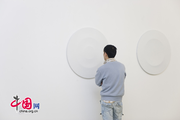 Visitors look at Huang Jia's abstract paintings