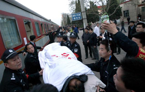 A rescued miner in relatively serious condition is carried on a stretcher into a train at the railway station in Hejin City, north China's Shanxi Province, April 6, 2010. Sixty of the 115 workers who were pulled out alive after being trapped for over a week in the flooded Wangjialing Coal Mine were transferred to key hospitals in the provincial capital Taiyuan Tuesday to receive better treatment. [Xinhua]