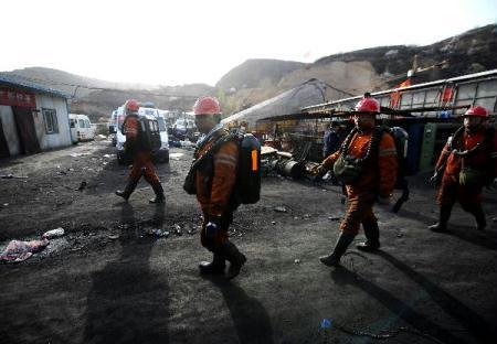 Rescuers walk out of the flooded Wangjialing Coal Mine in north China's Shanxi Province after continuously working for more than 10 hours underground early on April 6, 2010. 