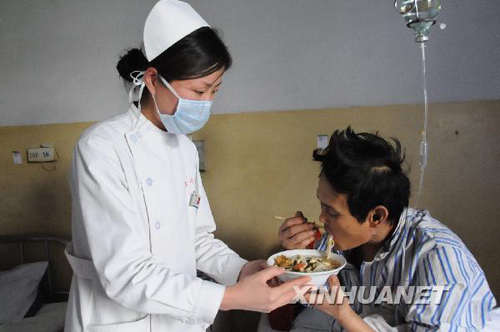 A survivor from the flooded Wangjialing Coal Mine in north China's Shanxi Province enjoys his first full meal in 10 days on Tuesday. 