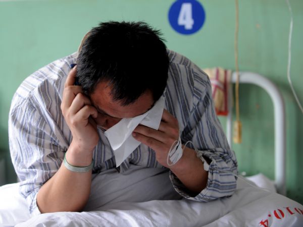 Yu Jianhua, a miner who survived the Wangjialing coal mine accident, talks to his parents on the phone at the Hejin Municipal People's Hospital in north China's Shanxi Province, on April 8, 2010. None of the 115 Chinese mine survivors trapped underground for more than a week were in critical condition, after they were miraculously rescued on Monday. (Xinhua
