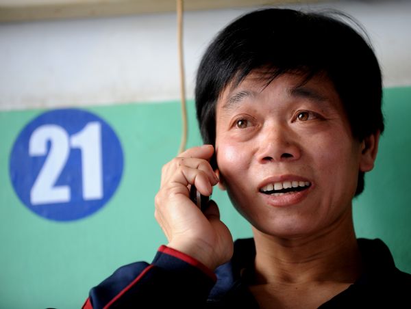 Liu Caiming, a miner who survived the Wangjialing coal mine accident, talks to his family on the phone at the Hejin Municipal People's Hospital in north China's Shanxi Province, on April 8, 2010.