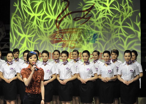 Participants pose onstage during the Air Hostess Contest TV show in Wuhan, capital of Central China&apos;s Hubei province on April 7, 2010.[Photo/Xinhua]