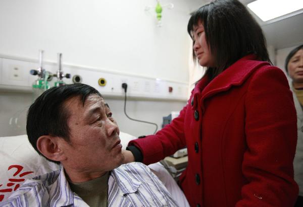 Wei Herong (L), a survivor of the Wangjialing coal mine accident, is visited by his daughter at a hospital in Taiyuan, capital of north China's Shanxi Province, on April 9, 2010. Two survived miners here whose health have recovered well were allowed by the hospital to meet with their relatives on Friday. (Xinhua