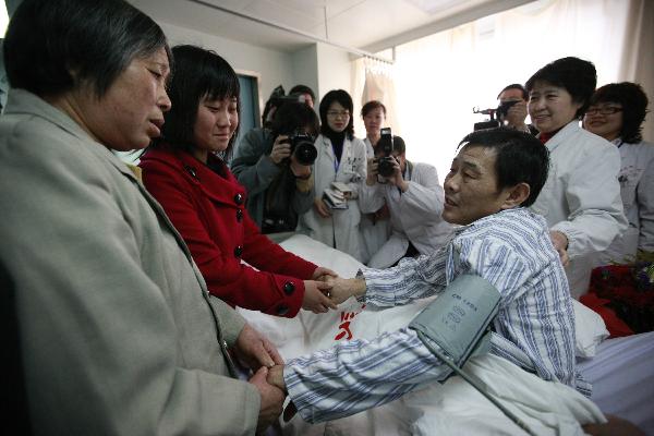 Wei Herong (R, front), a survivor of the Wangjialing coal mine accident, is visited by his daughter and mother-in-law at a hospital in Taiyuan, capital of north China's Shanxi Province, on April 9, 2010. 