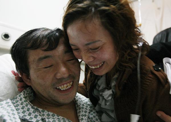 Liang Jinjun (L), a survivor of the Wangjialing coal mine accident, is hugged by his fiancee Zhang Fenyu at a hospital in Taiyuan, capital of north China's Shanxi Province, on April 9, 2010.