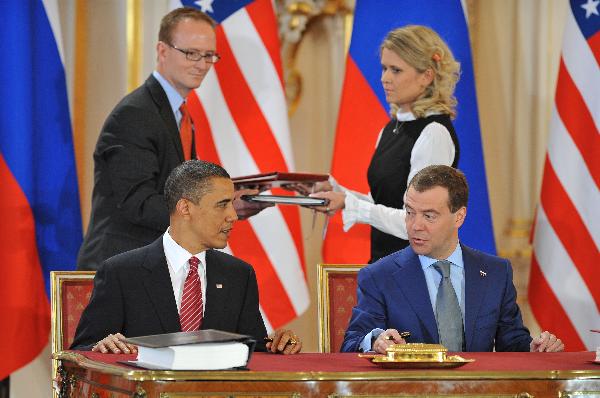 U.S. President Barack Obama (L) and his Russian counterpart Dmitry Medvedev sign a landmark nuclear arms reduction treaty in Prague, capital of Czech Republic, on April 8, 2010. Under the new pact, the two countries agreed to reduce their deployed nuclear warheads to 1,550 each, or 30 percent below the current level of 2,200, and cut the launchers below 700 each.[Wu Wei/Xinhua]