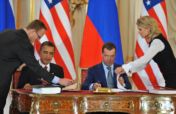 U.S. President Barack Obama (L) and his Russian counterpart Dmitry Medvedev sign a landmark nuclear arms reduction treaty in Prague, capital of Czech Republic, on April 8, 2010. Under the new pact, the two countries agreed to reduce their deployed nuclear warheads to 1,550 each, or 30 percent below the current level of 2,200, and cut the launchers below 700 each.[Wu Wei/Xinhua]