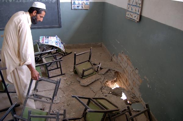 Staff memeber checks the school damaged by blasts in Peshawar, northwest Pakistan, April 8, 2010. Unidentified militants late night between Wednesday and Thursday attacked at least three schools located in separate parts of northwest Pakistan&apos;s Peshawar, police sources said. [Saeed Ahmad/Xinhua]