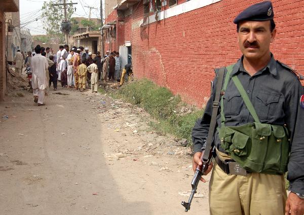 A security personnel guards outside the school damaged by blasts in Peshawar, northwest Pakistan, April 8, 2010. Unidentified militants late night between Wednesday and Thursday attacked at least three schools located in separate parts of northwest Pakistan&apos;s Peshawar, police sources said. [Saeed Ahmad/Xinhua]