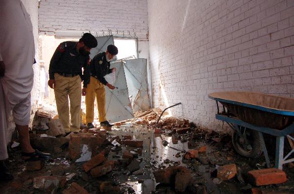 Security personnel check the school damaged by blasts in Peshawar, northwest Pakistan, April 8, 2010. Unidentified militants late night between Wednesday and Thursday attacked at least three schools located in separate parts of northwest Pakistan&apos;s Peshawar, police sources said. [Saeed Ahmad/Xinhua]