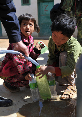  A student gets water dispatched by the local government at a school in South China&apos;s Guangxi Zhuang autonomous region on April 8, 2010. [Xinhua]