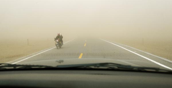 A motorcycle runs in the sandstorm beside Qinghai Lake in northwest China's Qinghai Province, April 9, 2010. A sandstorm hit Qinghai on Friday. [Hou Deqiang/Xinhua]