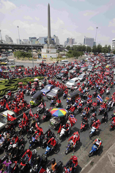 Anti-government protesters on motorcycles lead a march past the Victory monument to Thaicom Teleport and DTH Center during a rally in Pathum Thani on the outskirts of Bangkok April 9, 2010. [Xinhua] 