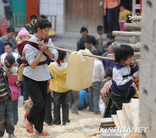 People carry water home from a local water supply station in Sanbao Village, Sanbao County of Guangxi Zhuang Autonomous Region, on March 29, 2010. 