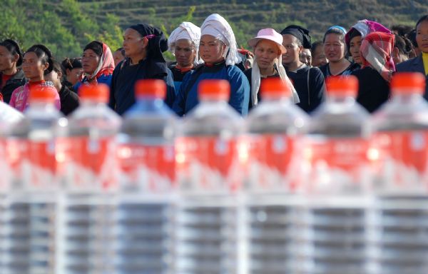 Photo taken on April. 8, 2010 shows local people waiting for collecting drinking water at a relief point in Puan county, southwest China's Guizhou province. More and more relief donations , mainly drinking water, come from every corner of the whole country to the drought-ravaged region.