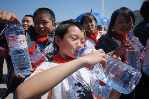 Photo taken on April. 8, 2010 shows pupils drinking water they received from the relief point in Puan county, southwest China's Guizhou province. More and more relief donations , mainly drinking water, come from every corner of the whole country to the drought-ravaged region.