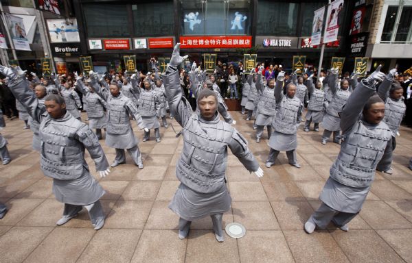 People dressed up as ancient 'terracotta warriors' perform on a street in Shanghai, April 10, 2010. The performance sponsored by the government of Xi'an, capital city of northwest China's Shaanxi Province, is part of the activities to promote the Shanghai Expo. The terracotta warriors and horses were discovered in 1974 in the mausoleum of Qinshihuang, the first emperor of the Qin dynasty who unified China, in northwestern Shaanxi Province.