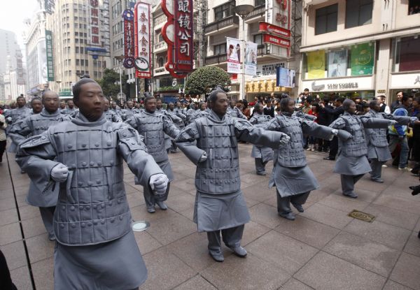 People dressed up as ancient 'terracotta warriors' perform on a street in Shanghai, April 10, 2010. The performance sponsored by the government of Xi'an, capital city of northwest China's Shaanxi Province, is part of the activities to promote the Shanghai Expo. The terracotta warriors and horses were discovered in 1974 in the mausoleum of Qinshihuang, the first emperor of the Qin dynasty who unified China, in northwestern Shaanxi Province.