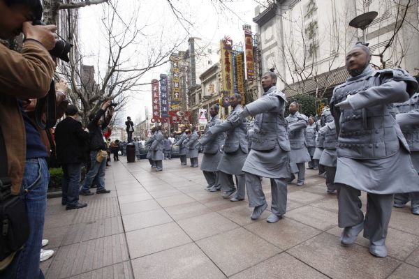 People dressed up as ancient 'terracotta warriors' perform on a street in Shanghai, April 10, 2010. The performance sponsored by the government of Xi'an, capital city of northwest China's Shaanxi Province, is part of the activities to promote the Shanghai Expo. The terracotta warriors and horses were discovered in 1974 in the mausoleum of Qinshihuang, the first emperor of the Qin dynasty who unified China, in northwestern Shaanxi Province.