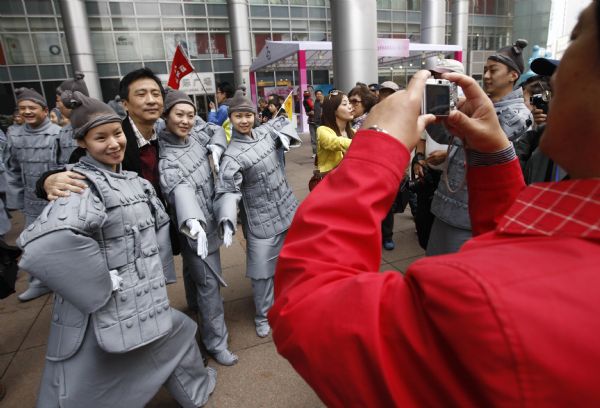 People dressed up as ancient 'terracotta warriors' perform on a street in Shanghai, April 10, 2010. The performance sponsored by the government of Xi'an, capital city of northwest China's Shaanxi Province, is part of the activities to promote the Shanghai Expo. The terracotta warriors and horses were discovered in 1974 in the mausoleum of Qinshihuang, the first emperor of the Qin dynasty who unified China, in northwestern Shaanxi Province.