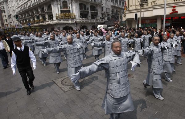 People dressed up as ancient 'terracotta warriors' perform on a street in Shanghai, April 10, 2010. The performance sponsored by the government of Xi'an, capital city of northwest China's Shaanxi Province, is part of the activities to promote the Shanghai Expo. The terracotta warriors and horses were discovered in 1974 in the mausoleum of Qinshihuang, the first emperor of the Qin dynasty who unified China, in northwestern Shaanxi Province.