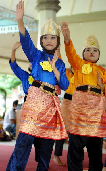 Pupils with folk dress perform traditional dance in Jakarta, capital of Indonesia, April 11, 2010.